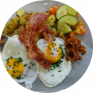 Frühstück in der cafete⁵⁵: 'SchMACofatz - knusprige Bratkartoffeln mit Bacon, Grillwürstchen und 2 Spiegeleiern (1,2,3,15), dazu ein Heißgetränk 0,2l