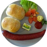 Frühstück in der cafete⁵⁵: 'Handwerker Teller' - je nach Angebot: Bockwurst, Frikadelle, Wiener, Knacker oder Wiegebraten mit doppeltem Brötchen und Butter (1,2,3,15,19,22,46,49,81,83), dazu ein Heißgetränk 0,2l