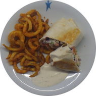 Chicken-Kebab-Wrap mit Hähnchenstreifen, Rotkohl, Weißkohl, Zwiebelringen und Kräutersoße (19,48,49,81) dazu Twister Pommes (81)