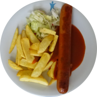 Gebratene Riesen-Currywurst vom Schwein 180 g (2,3,51,52) und Currysoße BBQ-Style (21,81) dazu Steakhouse Pommes und Garnitur