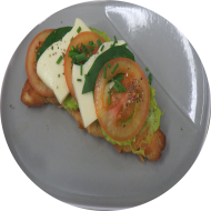 Frühstück in der Cafete: 'Smashed Croissant' - Geröstetes Buttercroissant mit hausgemachtem Avocadotatar dazu Tomate, Mozzarella und Basilikum (2,3,8,15,19,81) dazu ein Heißgetränk 0,2l (11,19)