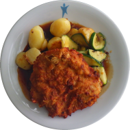 Hausgemachtes Schweineschnitzel 'Cipolla' in Zwiebelpanade (81,83) an Bratenjus dazu geschmortes Zucchinigemüse und Rosmarinkartoffeln (49)