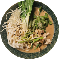 Shin Ramen in cremiger Erdnussbutter-Tahini-Brühe mit Tofu, Zuckerschoten und Porreeringe (2,17,18,23,81)