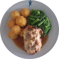 Schweinerückensteak 'Tiroler Art' mit Zwiebeln, Champignons und Schinken (2,3,8,19) an Thymianjus dazu Bohnengemüse und Herzoginkartoffeln (19)